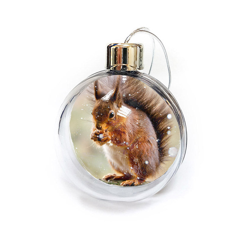 The Squirrel bauble by Available Light Photography features a charming scene of a squirrel eating in the snow, encased in a clear, round ornament with a silver cap and loop.