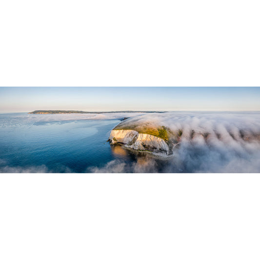 Aerial view of coastal cliff shrouded in fog, with clear blue sea and a horizon under a bright sky. Perfect for your Morning Fog, Culver Cliff product description or marketing material, this stunning image number 2248 from Available Light Photography captures natural beauty at its best.