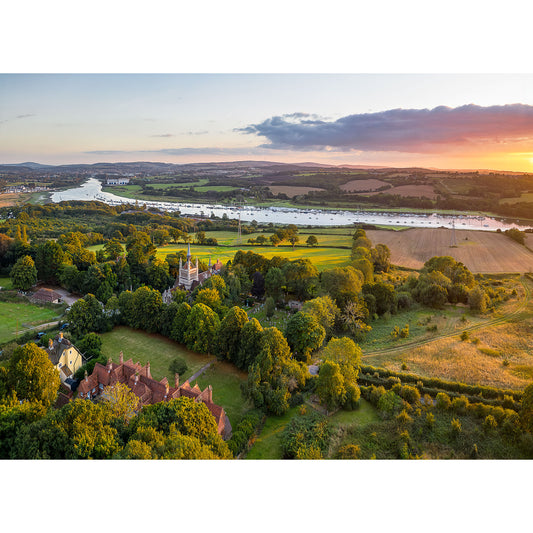 Aerial view of a countryside landscape featuring a river with boats, green fields, trees, and scattered houses at sunset. This serene scene captures the beauty of nature in Whippingham by Available Light Photography, image number 2808.