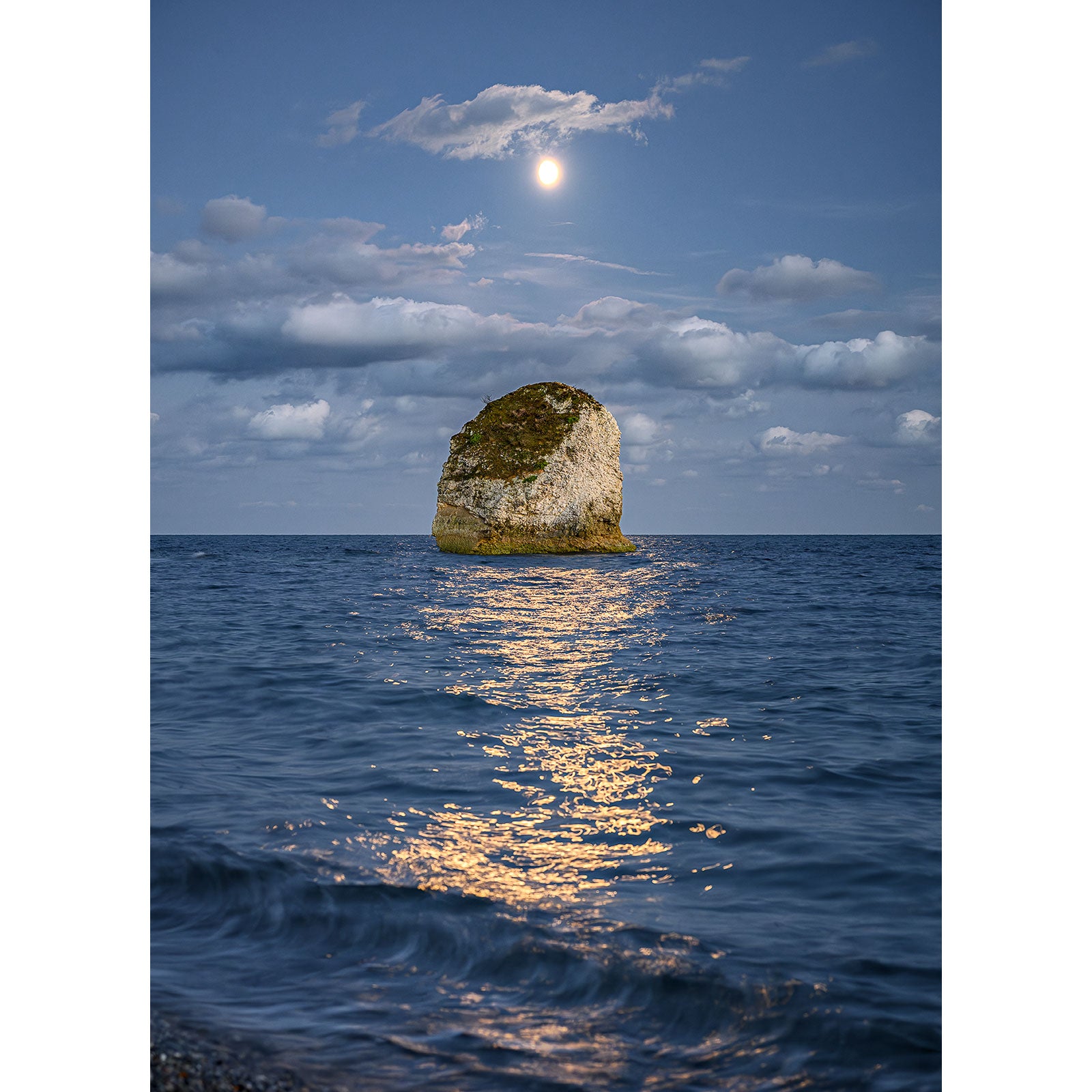 In the photograph titled "Moonlit Sea, Freshwater Bay" by Available Light Photography, a large rock formation juts out of calm ocean waters under a clear, moonlit sky with scattered clouds. The moonlight creates a glowing reflection on the water's surface in Image number 2904.