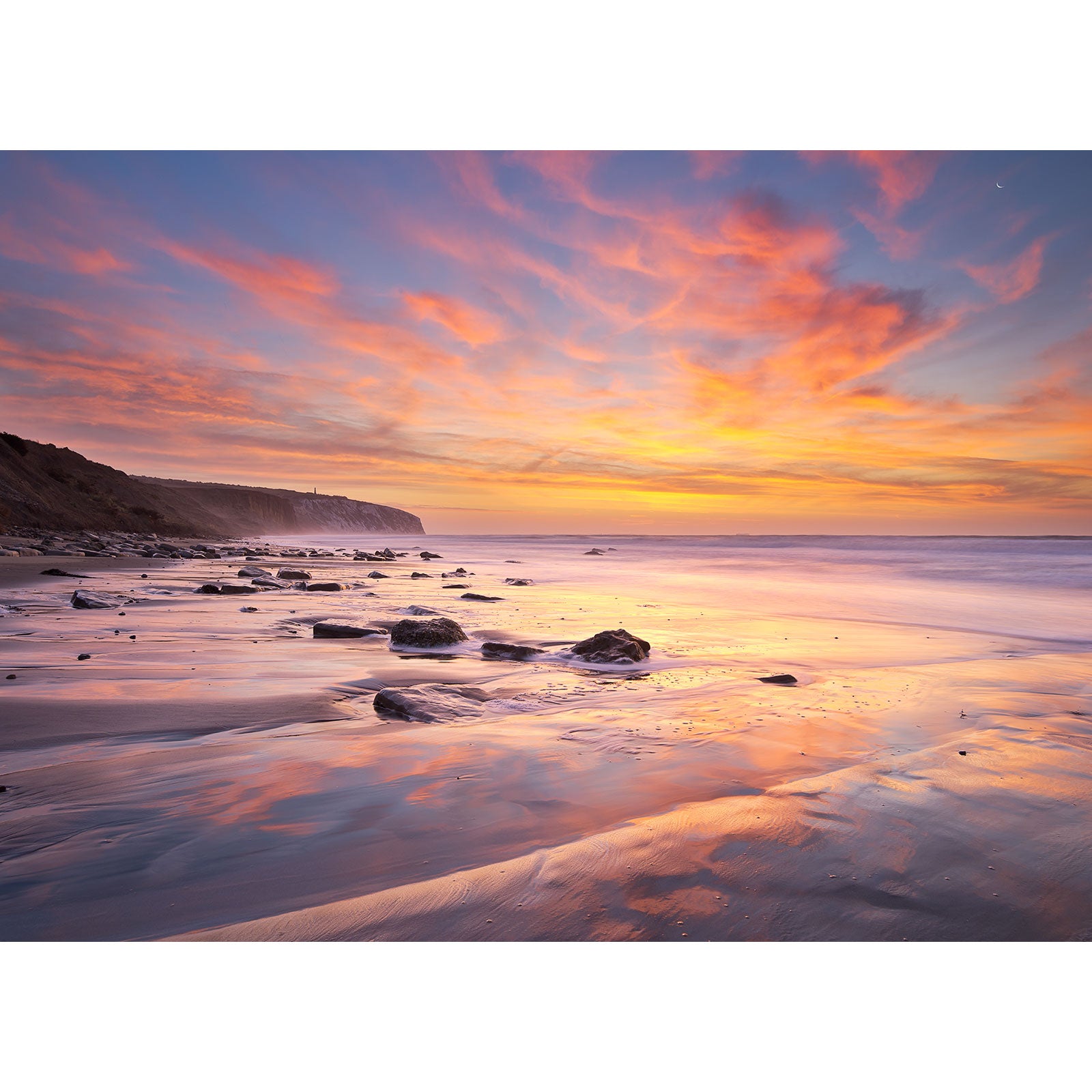 Tranquil Culver Cliff at sunset on the Isle of Wight with colorful skies and reflective tide pools by Available Light Photography.