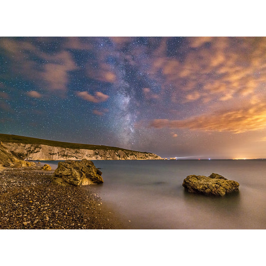 Replace the product in the sentence below with the given product name and brand name.
Sentence: Starry night sky over a serene coastline with rocky outcrops and cliffs on the Isle of Gascoigne under a blanket of clouds.
Product Name: Milky Way, The Needles
Brand Name: Available Light Photography

Revised Sentence: Milky Way galaxy shining above a serene coastline with rocky outcrops and cliffs on the Isle of Gascoigne captured by Available Light Photography.