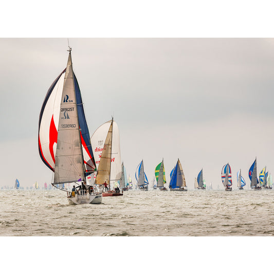 Sailing competition with multiple boats racing off the Isle of Wight on a cloudy day captured by Available Light Photography at the Round the Island Race.