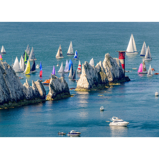 Sailboats racing past rocky outcrops on a bright day near the Isle of Gascoigne in the Round the Island Race captured by Available Light Photography.