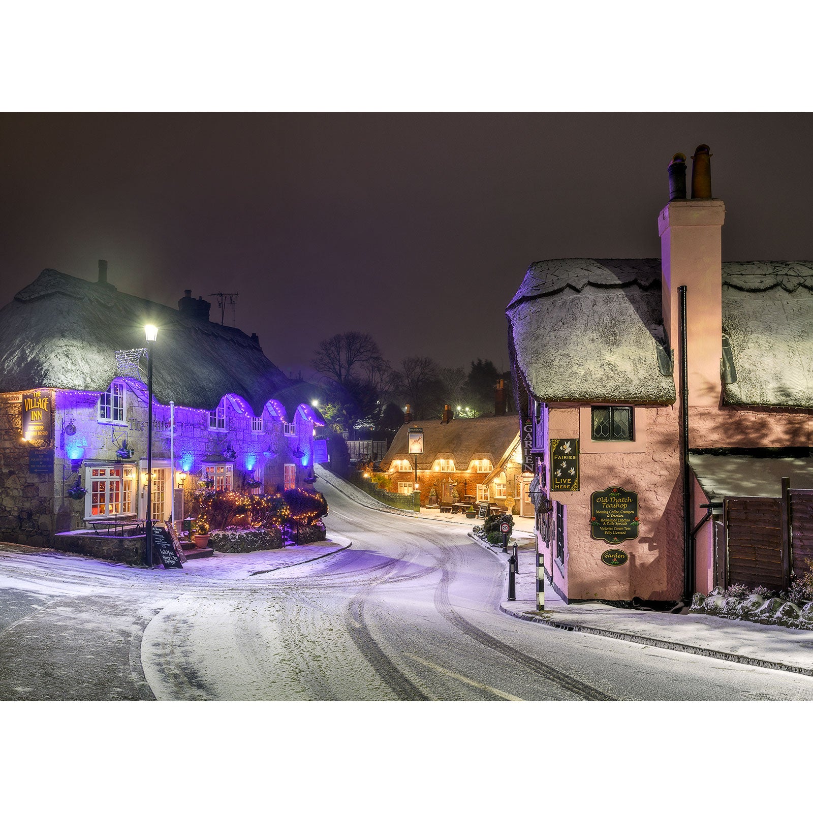 A Shanklin Old Village on the Isle at night with festive lights and thatched-roof buildings. Brand: Available Light Photography