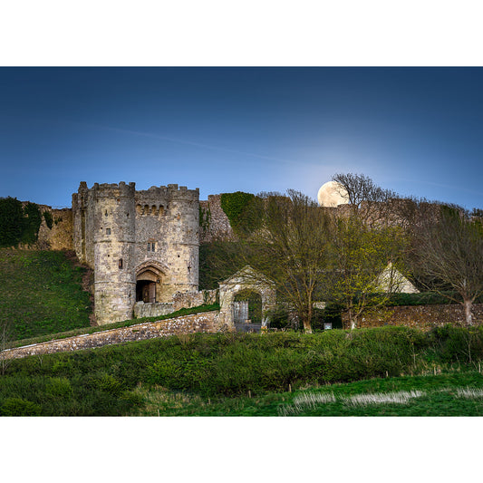 A Moonrise rising behind Carisbrooke Castle on the Isle of Wight amidst greenery by Available Light Photography.