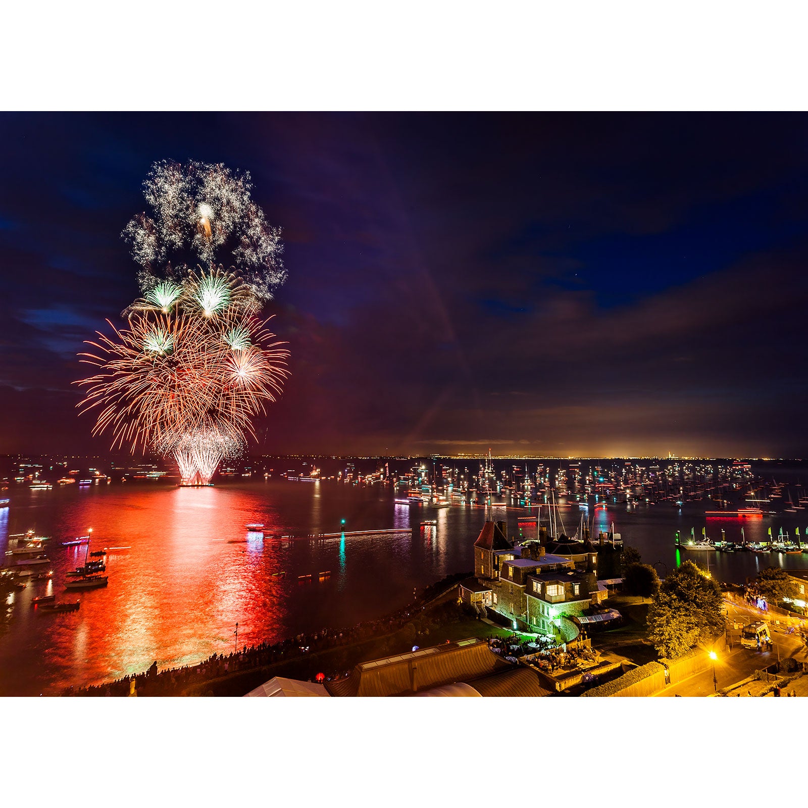 Fireworks display over the Gascoigne Isle waterfront at night by Cowes Week, captured by Available Light Photography.