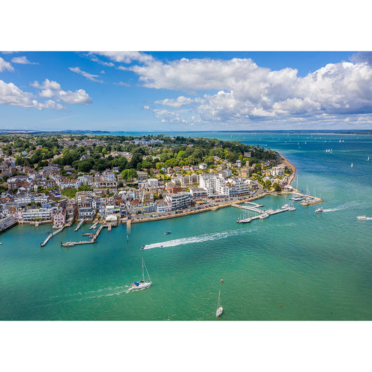 Aerial view of Cowes, a coastal town on the Isle of Wight with boats and clear waters under a partly cloudy sky, captured by Available Light Photography.