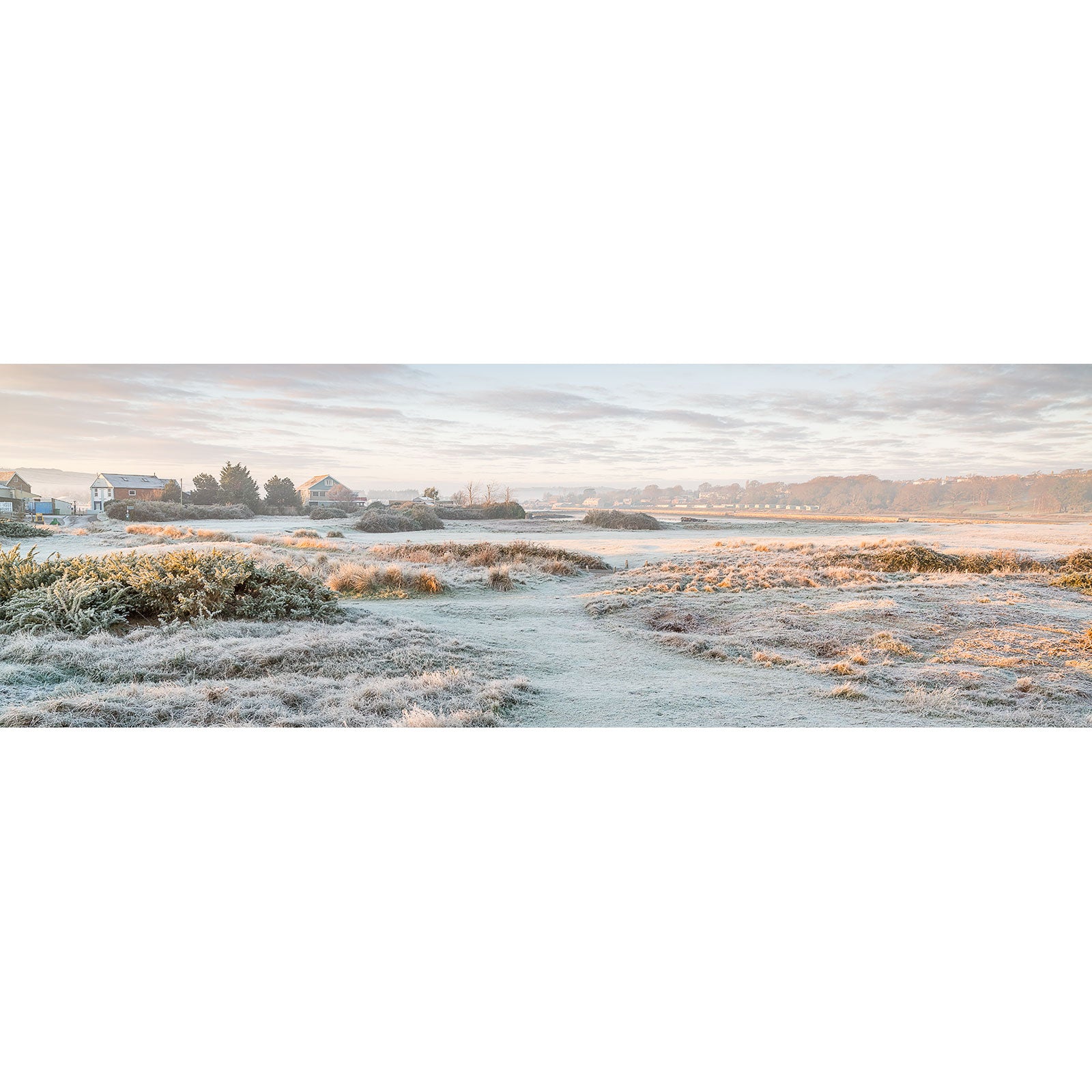 Frost-covered meadow at sunrise with a pathway and buildings on The Duver, St. Helens in the distance captured by Available Light Photography.