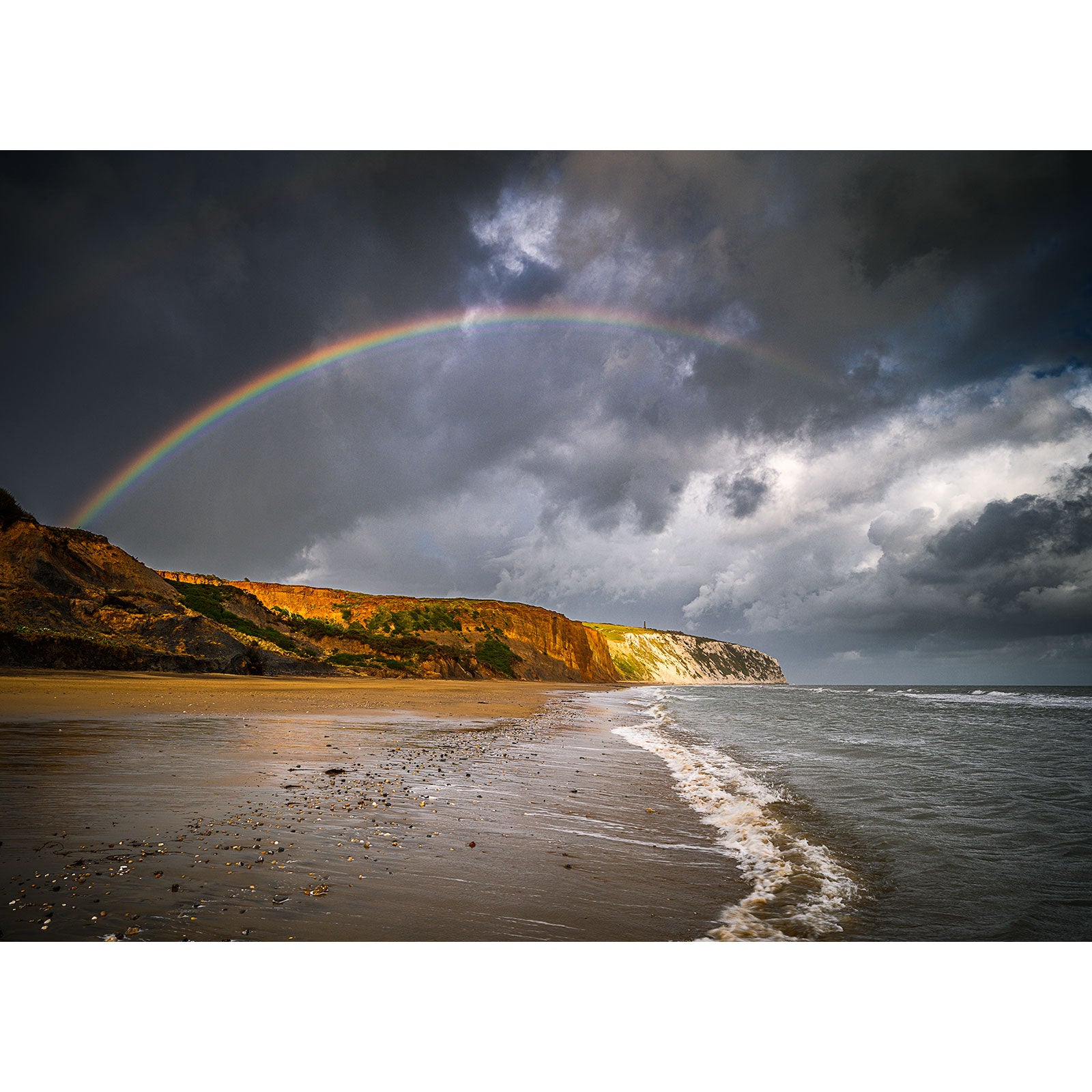 A Culver Cliff arches over a stormy beach with cliffs in the background on the Isle of Gascoigne by Available Light Photography.