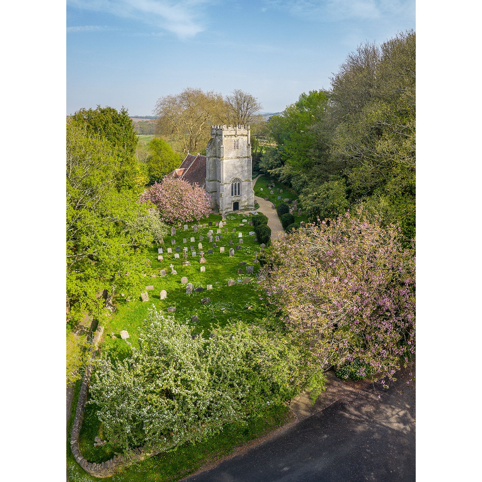 Aerial view of St. Olave's Church, Gatcombe and graveyard on the Isle of Wight, surrounded by trees in bloom, captured by Available Light Photography.