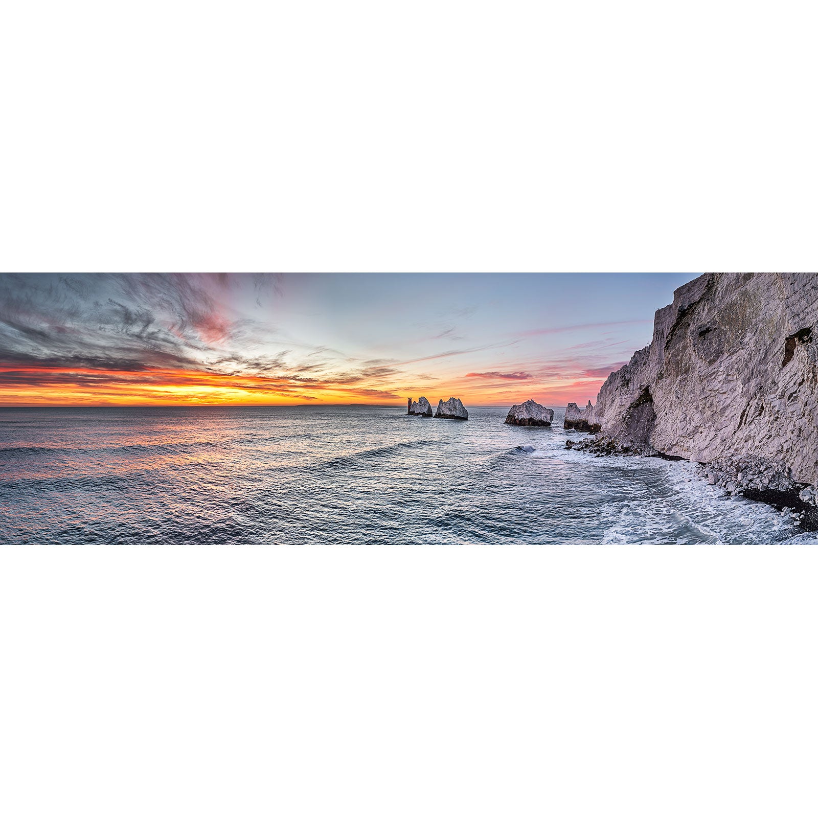 Scenic panorama of a coastal sunset with rock formations in the distance on the Isle of Gascoigne by Available Light Photography's The Needles.